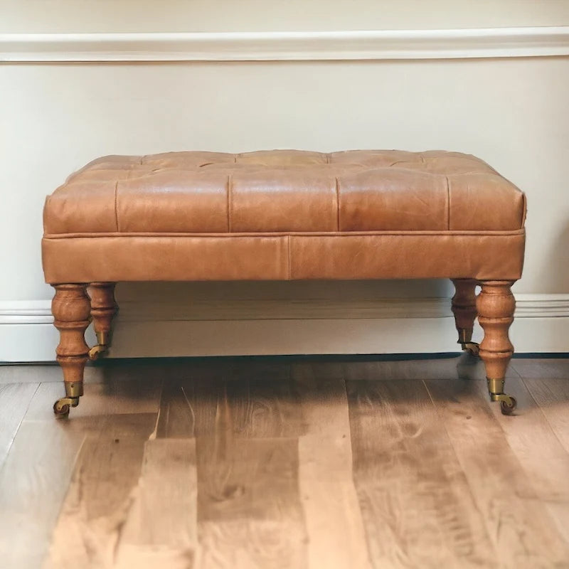 Pouf en cuir pleine fleur couleur havane, avec pieds à roulettes en bois massif