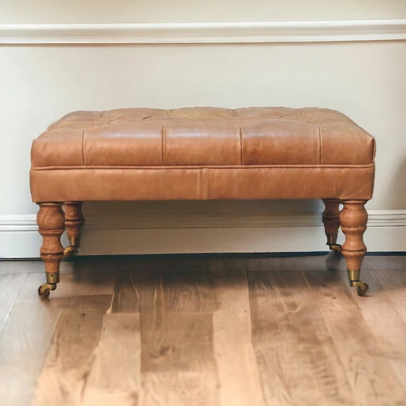 Pouf en cuir pleine fleur couleur havane, avec pieds à roulettes en bois massif